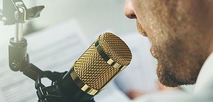 Mann spricht in ein Mikrofon.